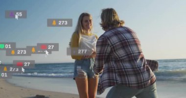 Sahilde evlenme teklif eden çift, sosyal medya bilgilendirmeleriyle çevrili. Nişan, romantizm, kutlama, dijital