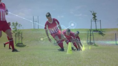 Futbol oyuncuları koni ile antrenman yapıyor, saha üzerinden ağ bağlantıları kuruyor. Futbol, egzersiz, takım çalışması, dijital, teknoloji, bağlantı