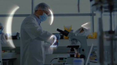 Laboratuvardaki çeşitli bilim adamları üzerinde veri işleme animasyonu. Küresel bilim, bağlantılar, hesaplama ve veri işleme kavramı dijital olarak oluşturulmuş video.