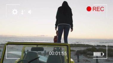 Arabanın üzerinde duran, plaj manzarasının keyfini çıkaran zamanlayıcı animasyonlu bir kadın. Tatil, seyahat, rahatlama, güneşli, yaz, özgürlük