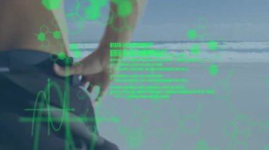 Sahilde dalış kıyafetini ayarlayan kişi üzerinde yeşil altıgen desenler ve veri animasyonu. Teknoloji, yenilik, sörf, dijital, gelecekçi, okyanus