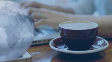 Laptopta kahve fincanı ile yazı yazmak, dünya animasyonu sahnenin üzerinde. Teknoloji, iş, üretkenlik, uzaktan çalışma, kafein, küresel