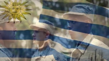 Çeşitli erkek askerlerin selamlaması üzerine uruguay bayrağının animasyonu. Askeri, vatanseverlik ve bayraklar dijital olarak üretilen video konsepti.