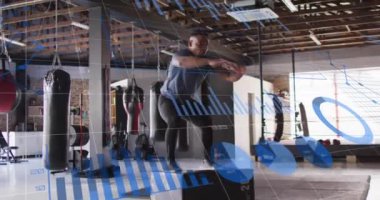 Spor salonunda egzersiz yapan bir adam spor aletleri üzerinde veri analiz animasyonu yapıyor. eğitim, egzersiz, teknoloji, atlet, sağlık, performans