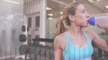 Şişeden içmek, spor salonundaki kadın olay yerindeki verileri canlandırmak. egzersiz, hidrasyon, teknoloji, egzersiz, sağlık, izleme
