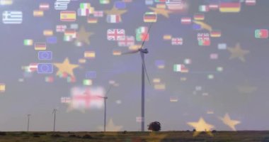 Rüzgâr türbinleri yüzen kır bayraklarıyla birlikte arazide. Yenilenebilir enerji, sürdürülebilirlik, çevre, rüzgar gücü, temiz enerji