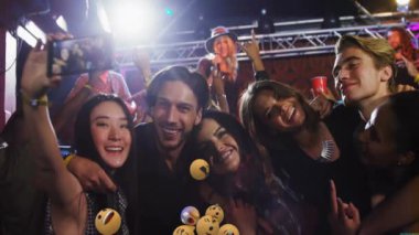 Bir grup arkadaş yüzen emoji animasyonlarıyla selfie çekiyorlar. Sosyal medya, eğlence, teknoloji, mutluluk, eğlence, gençlik