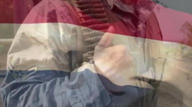 Üniforma giyen beyaz erkek askerin üzerinde Hollanda bayrağının canlandırılması. Askeri, vatanseverlik ve bayraklar dijital olarak üretilen video konsepti.