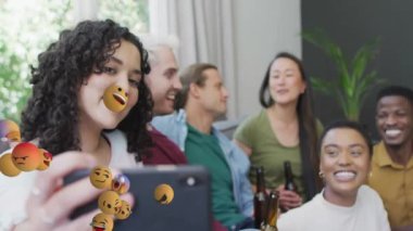 Grup selfie 'si çekiyoruz, arkadaşlar havada süzülen emoji animasyonlarıyla çevrili. Sosyal medya, eğlence, emojiler, grup fotoğrafı, mutluluk, neşe
