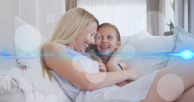 Kanepede konuşan mutlu beyaz anne ve kızın üzerinde hareket eden ışık ve noktaların görüntüsü. V