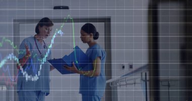 Mavi önlüklü Kafkas kıdemli ve melez stajyer dijital verileri konuşuyor. Her ikisi de mavi arkaplanlı parlayan grafiklere odaklanıyor, eğilimleri analiz ediyor