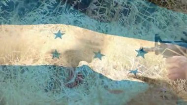 Honduras bayrağının, tüfekli beyaz erkek asker üzerinde canlandırılması. Askeri, vatanseverlik ve bayraklar dijital olarak üretilen video konsepti.