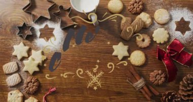 Mutlu noel metinleri, neşeli kurabiyeler ve ahşap masada pişirme malzemeleri üzerine. Tatil, kutlama, dekorasyon, gelenek, kış, ev yapımı