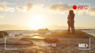 Gün batımında plajda kucaklaşan çift, kamera önünde animasyon kaydediyor. Aşk, aşk, sarılma, video, tutku, deniz kenarı