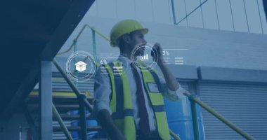 Sanayi işçisi telsiz kullanıyor, fabrika arka planında veri işleme animasyonu yapıyor. Sanayi, üretim, teknoloji, iletişim, otomasyon, ekipman