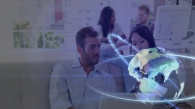 Ofis arka planında küresel ağ animasyonu olan dizüstü bilgisayar kullanan gülümseyen bir çift. Teknoloji, iş, takım çalışması, bağlantı, iletişim, işbirliği