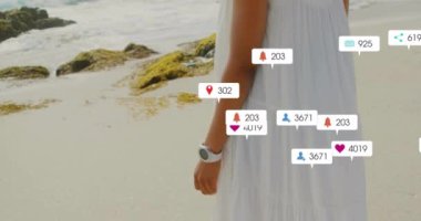 Plajda dikilen kadın hakkında sosyal medya bilgilendirmeleri. Teknoloji, akıllı telefon, çevrimiçi, dijital, sosyal ağ, sanal