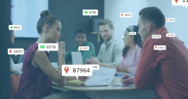 Sosyal medya simgelerinin, çeşitli erkek ve kadınların ofiste bir belge üzerinde tartışmaları üzerine görüntüsü. Sosyal medya ağı ve iş teknolojisi kavramı