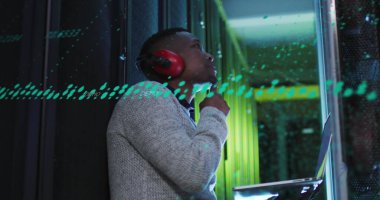 Sunucu odasında dizüstü bilgisayarı olan düşünceli Afro-Amerikan erkek mühendis görüntüsü. Bilgisayar arayüzü ve iş veri depolama teknolojisi kavramı