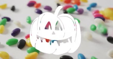 Beyaz arka plana saçılmış renkli jelibonlar üzerinde fener animasyonu. Cadılar Bayramı, ürkütücü, şenlikli, şeker, ikram, dekorasyon