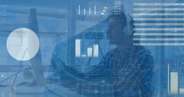 Ofiste bilgisayar kullanarak kulaklık takan beyaz bir adamın veri işleme görüntüsü. İş veri teknolojisi kavramı