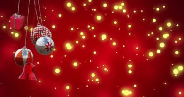 Kırmızı arka plandaki ışık noktalarının üzerinde noel süslerinin canlandırılması. Noel, gelenek ve kutlama konsepti dijital olarak oluşturuldu.