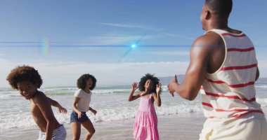 Sahildeki Afro-Amerikan ailesinin üzerindeki ışık noktaları. Tatiller, boş zaman ve dijital arayüz kavramı dijital olarak oluşturulmuş görüntü.