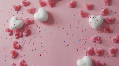 Kalp ve konfeti animasyonu pembe arka planda dağınık kalp dekorasyonlarıyla. Sevgililer günü, romantizm, kutlama, aşk, şenlik, neşe