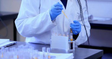 Laboratuvardaki Afrikalı Amerikalı kadın bilim adamının üzerindeki şekiller. Küresel eğitim, bilim ve dijital arayüz kavramı dijital olarak oluşturulmuş görüntü.