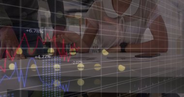 Kafkas iş adamları modern ofiste bir belgeyi tartışıyorlar. Bir kadın dijital tabletinde değişen borsa rakamlarını ve grafiklerini görüyor, fiyatları takip ediyor.