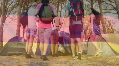 Alman bayrağı animasyonuyla kamp yapan bir grup arkadaş ormanın arka planında. Açık hava, çeşitlilik, doğa, birlik, macera