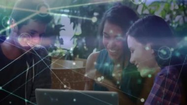 Ağ ve veri bağlantıları dizüstü bilgisayarın etrafında gülen arkadaşlar üzerine kurulmuş. teknoloji, bağlantı, kahkaha, işbirliği, sosyalleşme