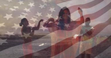 Sahilde kutlama, arka planda Amerikan bayrağı animasyonu olan insanlar. Kutlama, vatanseverlik, arkadaşlar, bağımsızlık, yaz