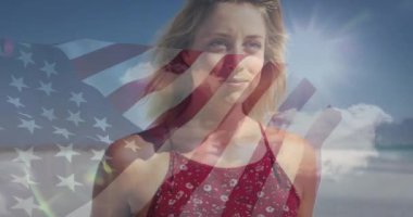 Sahilde gülümseyen kadın, arka planda Amerikan bayrağı animasyonuyla. Vatanseverlik, yaz, kutlama, özgürlük, tatil, ABD