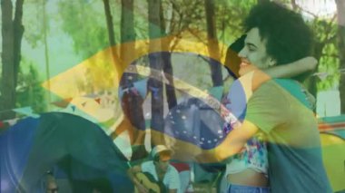 Dışarıda kamp yapmaktan hoşlanan, arka planda Brezilya bayrağı animasyonu olan insanlar. Açık hava, macera, seyahat, boş zaman, yaz tatili, vatanseverlik