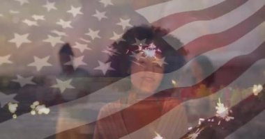 Amerikan bayrağı animasyonunun önünde havai fişek tutan, gülümseyen kadın. Kutlama, bağımsızlık, vatanseverlik, bayram, neşe