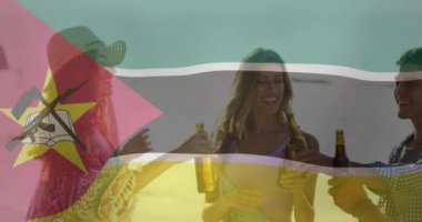 Arkadaşların sahilde bira şişeleriyle kadeh kaldırması üzerine Mozambik bayrağı animasyonu. Kutlama, plaj partisi, arkadaşlık, yaz, tezahürat, tatil