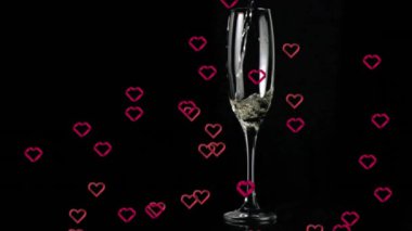 Siyah arka planda düşen kupa animasyonunun üzerinde baloncuklar olan şampanya bardağı. Kutlama, şenlik, aşk, aşk, parti