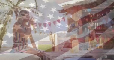 Açık sahil barında içki içen kadınlar üzerine Amerikan bayrağı animasyonu. Vatanseverlik, kutlama, yaz, tatil, arkadaşlar, yaşam tarzı