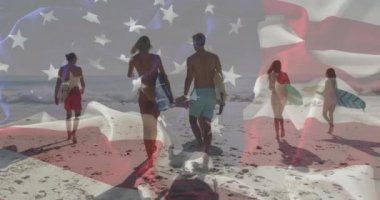 Sahilde sörf tahtasıyla yürüyen bir grup insan üzerinde Amerikan bayrağı animasyonu. Vatanseverlik, sörf, boş zaman, açık hava, tatil, toplum