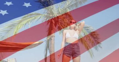 Güneş gözlüklü bir kadının palmiye ağacının yanında dikilmesi üzerine Amerikan bayrağı animasyonu. Vatanseverlik, bağımsızlık, özgürlük, yaz, plaj, moda kavramı