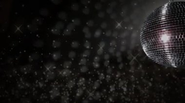 Pırıl pırıl parlayan ışıklar eşliğinde dönen disko topu koyu arkaplanda canlanıyor. Parti, dans, gece hayatı, kutlama, ışıltı, eğlence