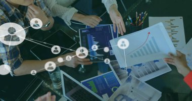 Ofisteki raporları tartışan ve analiz eden çeşitli iş arkadaşlarıyla bağlantılı simgelerin resmi. Dijital bileşik, çoklu pozlama, iletişim, planlama, takım çalışması ve teknoloji kavramı.