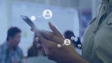 Akıllı telefon kullanan iki ırklı iş kadınının üzerindeki simgelerle olan bağlantıların animasyonu. İş ve dijital arayüz kavramı dijital olarak oluşturulmuş video.