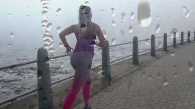 Gezintide koşan beyaz bir kadının üzerine su damlaları düşmesi. Spor, sağlık ve yaşam tarzı konsepti dijital olarak oluşturulmuş video.