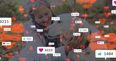 Kafkasyalı son sınıf öğrencisi kadın, ikisi de açık havada büyük köpeğe sarılıyor. Kısa gri saçları, açık renk kırışıklıkları var ve mavi bir bluz giyiyor.