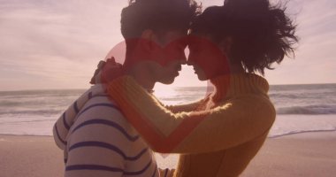 Kumsalda birbirini kucaklayan bir çiftin kırmızı kalbi. Sevgililer Günü, aşk ve romantizm kavramı dijital olarak oluşturuldu.