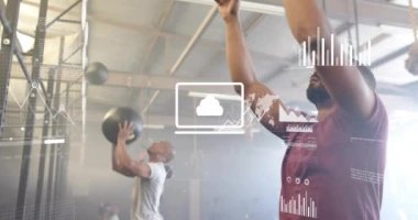 Spor salonunda toplarla egzersiz yapan farklı adamların veri işleme ve diyagramlarının animasyonu. Spor ve dijital arayüz konsepti dijital olarak oluşturulmuş video.