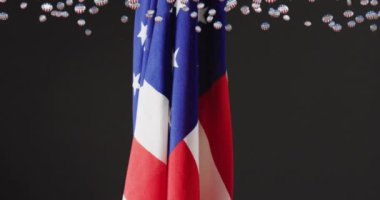 Düşen Amerikan seçim rozetlerinin ve siyah arka planda Amerikan bayrağının animasyonu. Amerika, siyaset, demokrasi, kutlama, hükümet, seçim ve oylama, dijital olarak oluşturulmuş video.