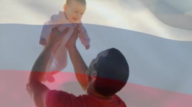 Kafkasyalı bir babanın bebeği taşıması üzerine rusya bayrağının canlandırılması. Yaşam tarzı, bayraklar ve vatanseverlik konsepti dijital olarak oluşturulmuş video.